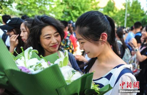 資料圖：山東濟南眾多考生手捧鮮花在家長的簇擁下歡快告別高考。中新社記者 張勇 攝