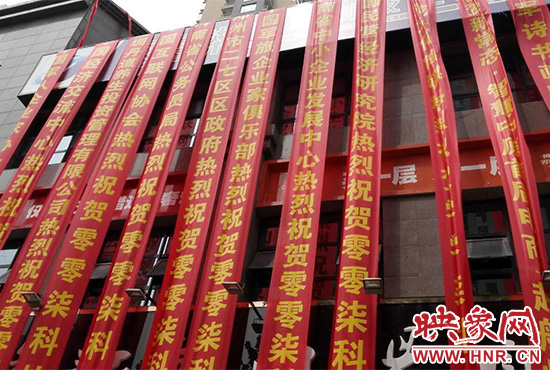 路邊一棟樓上懸掛著二三十條紅色條幅，全部是祝賀一家公司開業(yè)的。