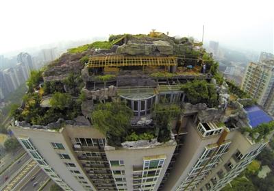 　　昨日，身穿橘黃色馬甲的工作人員在人濟(jì)山莊樓頂拆除違章建筑。新京報(bào)記者 吳江 攝