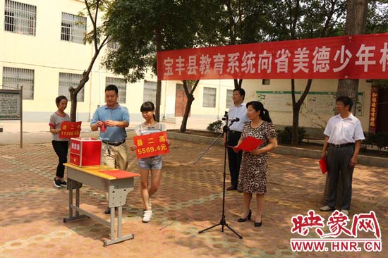寶豐縣教育系統(tǒng)全體人員在石橋鎮(zhèn)中學為“美德少年”楊冠明同學捐款。