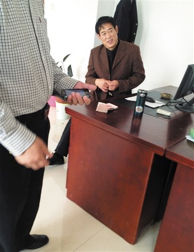 10月29日，獻(xiàn)縣國稅局稽查局辦公室內(nèi)，一名企業(yè)主交了兩萬元現(xiàn)金在桌上。新京報(bào)記者 孟祥超 攝