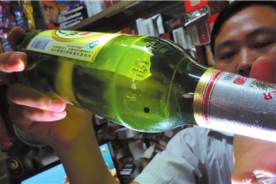 這瓶未開(kāi)封的燕京啤酒內(nèi)有一顆黑色懸浮物。京華時(shí)報(bào)記者 徐曉帆 攝