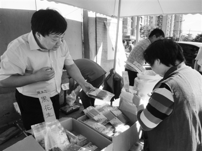 昨日，河南企業(yè)家劉春喜在京“練攤”，為顧客挑選綠豆。新京報(bào)記者 張玉學(xué) 攝