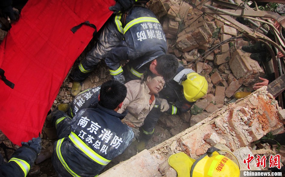 圖為南京消防隊員從廢墟中將傷者抬出。中新社發(fā) 梅亮 攝