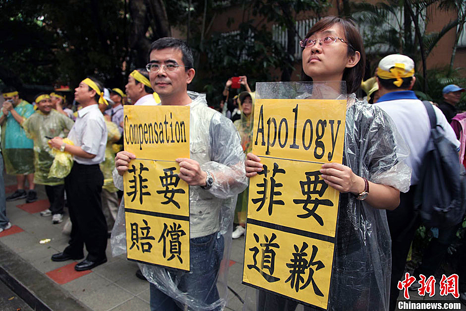 　圖為當(dāng)天下午，當(dāng)臺(tái)灣數(shù)百漁民在馬尼拉經(jīng)濟(jì)文化辦事處前抗議時(shí)，有兩名年輕人手持標(biāo)語(yǔ)，在路邊聲援。中新