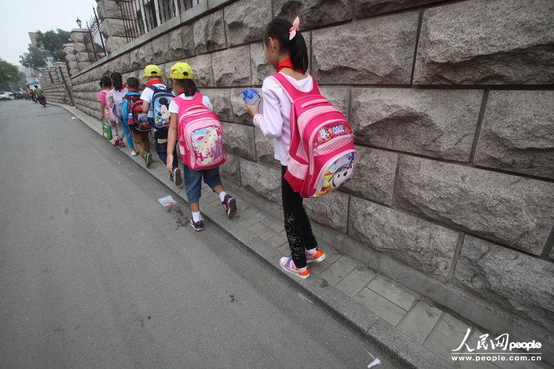 2013年09月11日，濟(jì)南運(yùn)署街上，小學(xué)生走史上“最窄人行道”上學(xué)。