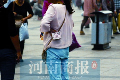 火車站廣場(chǎng)，一女子拿著寫有不同房型價(jià)位的卡片在拉客，不少市民抱怨，受過此類“騷擾”