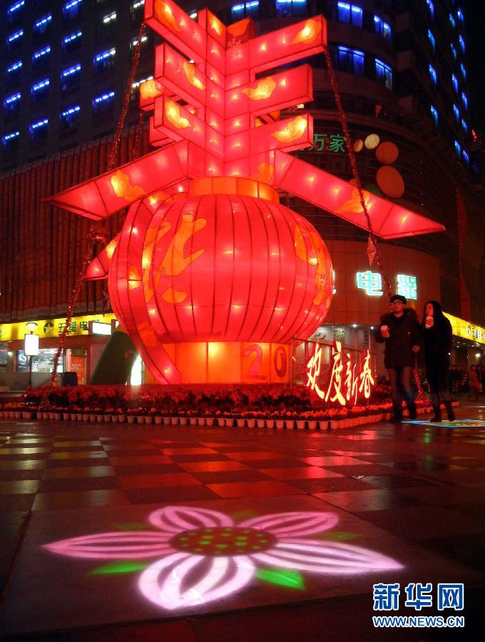 　1月30日晚，市民從蘇州市石路銀河廣場上大型“春”字彩燈景觀旁經(jīng)過。