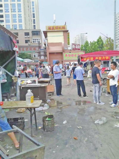 昨天，執(zhí)法人員在京廣路長(zhǎng)江路口整治“僵尸圍擋”及圍擋內(nèi)的攤販。