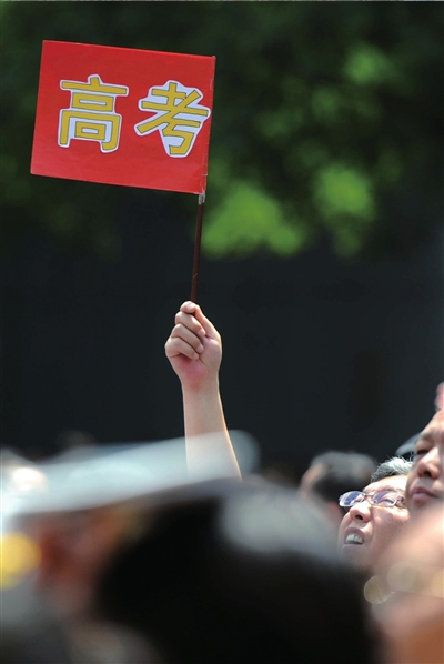 6月7日，在東直門考點(diǎn)外，一名家長(zhǎng)手舉高考的小旗子迎接孩子。資料圖片本報(bào)記者王苡萱攝