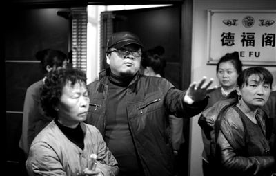 昨日，在河北香河天下第一城，相關(guān)負(fù)責(zé)人（左二）走出會議室與參加演出的老人們溝通。