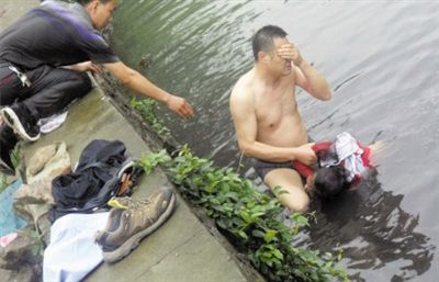 網(wǎng)友貼出民警張光聰一出河水就睜不開眼，用手抹去臉上臟水的照片。