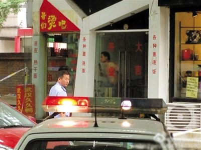闖入面館的持刀男子與趕來的民警隔著玻璃門對(duì)峙，后店內(nèi)一名女童被其劫持。網(wǎng)友供圖