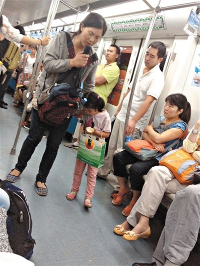 6月27日，舒馨帶一女孩在地鐵十號線行乞。她因被疑帶多個不同小孩乞討被警方搜尋。新京報記者 申志民 攝