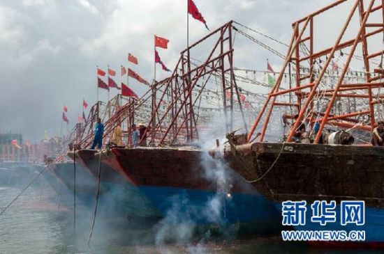 2013年8月1日 南海開漁日 臨高迎新港 8月1日，海南省臨高縣漁民在船上鳴放鞭炮慶祝武蓮港開港。