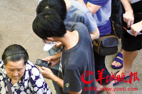 排隊的“黃?！备魇謭?zhí)一疊白紙，上面寫好了要掛號的人的信息，包括姓名、電話、要掛的科室等。穿黑白花紋衣服的老婆婆正在排隊掛號