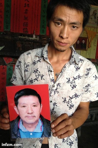 程興貴的兒子程正鵬拿著父親的遺照。程興貴自殺后，政府補償程家6000多塊錢，并終于認定了程興貴的代課教齡。 (南方周末記者雷磊/圖)
