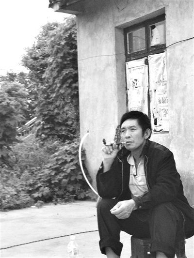9月12日，陳文才在自己的出租屋旁抽煙。新京報(bào)記者 朱柳笛 攝