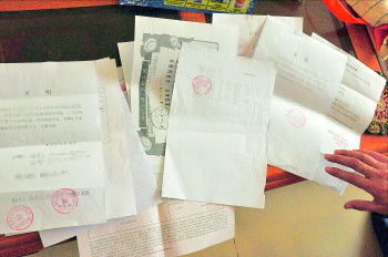 60歲的市民仇先生為了辦理公證所需的這些證明材料,半個月時間里跑了30多趟腿。記者　李萌博　攝