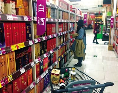 顧客在商場(chǎng)的高檔白酒貨架前駐足挑選。春節(jié)臨近，受“禁令”影響，以高檔白酒為代表的節(jié)日禮品市場(chǎng)面臨考驗(yàn)。記者 王遠(yuǎn)征 攝