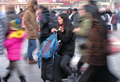 春運(yùn)首日，北京站客流量明顯增多，一名女孩在人流中等待進(jìn)站。