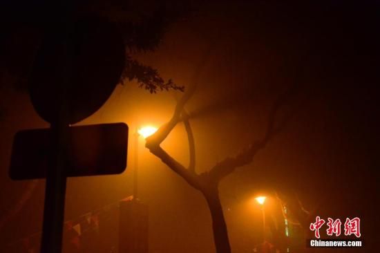 1月31日凌晨，市民行走在煙霧繚繞的南京街頭。當(dāng)天是農(nóng)歷馬年正月初一，南京有限開禁燃放煙花爆竹正逢下霧天，空氣的不流通致使煙花爆竹燃燒后產(chǎn)生的顆粒物不能及時散開，造成整座城市煙霧繚繞。據(jù)當(dāng)?shù)丨h(huán)保部門發(fā)布的信息顯示，空氣質(zhì)量屬重度污染。中新社發(fā) 泱波 攝