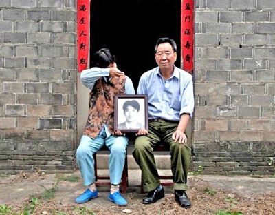 江蘇鎮(zhèn)江，老劉夫婦捧著獨(dú)生子的遺像在老家前留影南方都市報(bào)供圖L