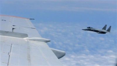 國防部網(wǎng)站12日公布的視頻截圖,日本F-15軍機從中國圖-154機頭方向危險切入,兩者最近距離約30米左右。