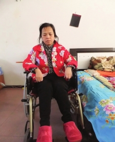 陳慶霞坐在輪椅上。她現(xiàn)在下身癱瘓，疾病纏身，生活不能自理。