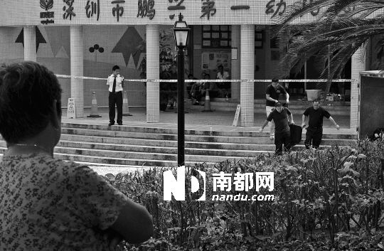 →7月19日，鵬興花園第一幼兒園門前，民警在現(xiàn)場(chǎng)進(jìn)行完勘查取證后，園長和保安的尸體被運(yùn)走。南都記者 徐文閣 攝