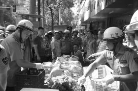 7月11日，瀏陽市北正中路，執(zhí)法人員暫扣張海的水果。這是瀏陽市城管局拍攝的執(zhí)法現(xiàn)場圖。