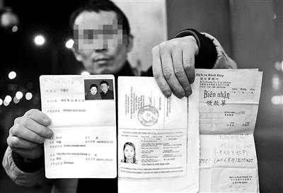 賀先生向記者出示他與越南妻子的結(jié)婚證、新娘護(hù)照和部分相關(guān)交費單據(jù) 攝影/本報記者　袁藝