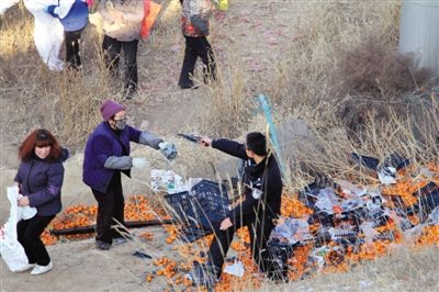 1月4日，連霍高速蘭州市榆中縣和平鎮(zhèn)段，一名警察舉著槍驅(qū)散哄搶橘子的村民。圖/CFP