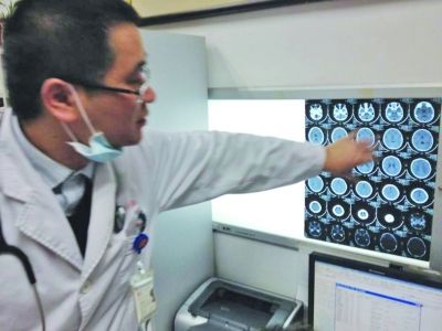 醫(yī)生在查看男孩的腦部CT片。薛馬義 攝