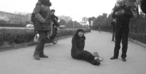 鄭大姐坐在地上，警方趕到進行施救。（視頻截圖由警方提供）
