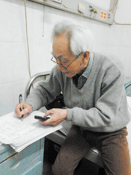 杜修源老人埋頭寫著特殊的“日記”。 李卓 攝