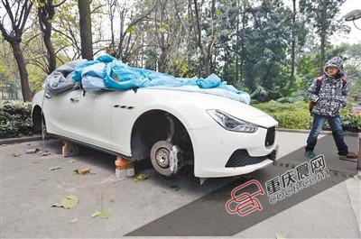 昨日，停放在重慶大學(xué)B區(qū)的一輛瑪莎拉蒂豪車被架在幾塊磚頭上，車輪不翼而飛。 重慶晨報(bào)記者 胡杰 攝