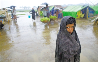 5月14日，緬甸若開邦實(shí)兌難民營，羅興亞族難民在雨中行走。熱帶風(fēng)暴“馬哈森”即將登陸緬甸，這里的難民開始乘船撤離。