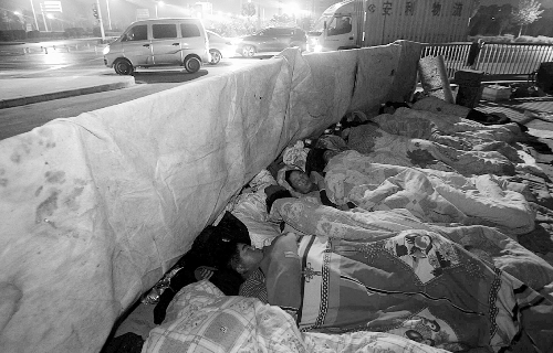 在寒冷的冬夜，為了能省點(diǎn)錢，方便接活，民工們?nèi)运跇蛳隆? complete=