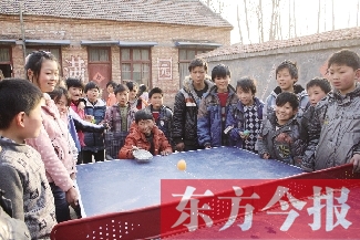 坐著輪椅的小宗成和同學(xué)們一塊打乒乓球，這是他感到最快樂(lè)的事