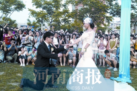 在學(xué)校操場的草坪上，兩名畢業(yè)生舉行婚禮，有同學(xué)感動地抹起眼淚