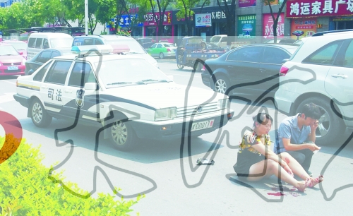 事故發(fā)生后，警車司機（右）下車查看傷者并撥打120，倆“領導”穩(wěn)坐車內引發(fā)圍觀者不滿。