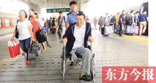 李剛手術(shù)后歸來(lái)，在車站工作人員幫助下走出鄭州火車站站臺(tái)  東方今報(bào)首席記者 張曉冬 攝