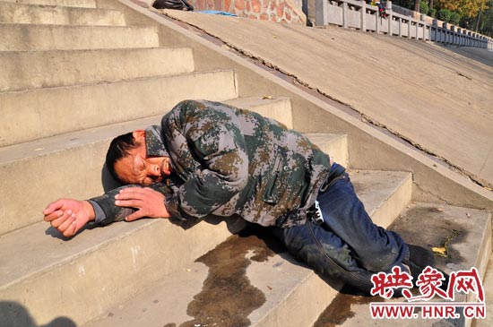 這名男子的衣服以及褲子全濕透了，水從衣褲里流出來，嘴里散發(fā)著濃烈的酒氣。