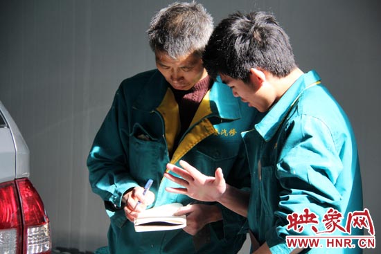 在汽修廠(chǎng)干了20來(lái)年的李師傅（左）在教一個(gè)聾啞人修車(chē)技巧