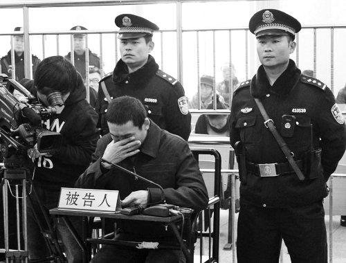 庭審中,29歲的李軍低著頭。