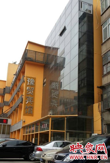 該酒店為加蓋樓層統(tǒng)一安裝上黑色玻璃，從前面看不出加蓋的痕跡