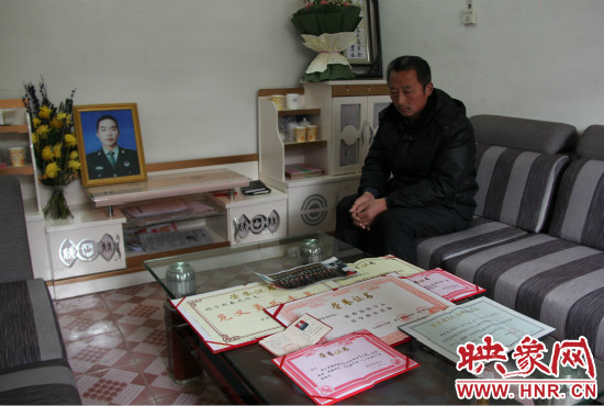 救火英雄鄭春光的父親和兒子獲得榮譽(yù)證書。