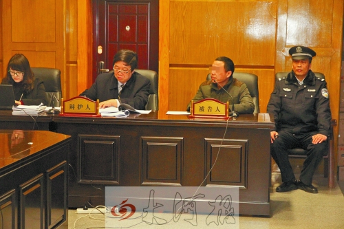 庭審現(xiàn)場，被告人坐在律師身旁為自己辯護(hù)。