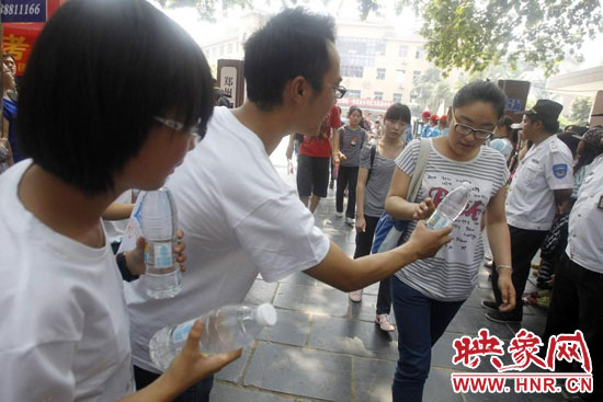 志愿者為剛剛考試完的考生送上1瓶冰凍的冰露·純悅，消暑解渴為考生加油